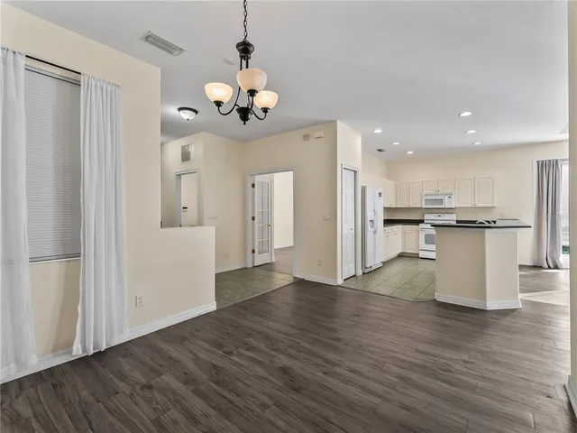 a large kitchen with white cabinets and white appliances