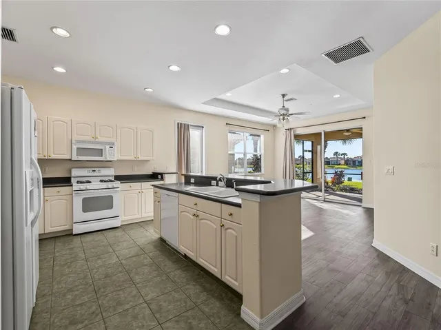 a kitchen with granite countertop a sink and white stainless steel appliances