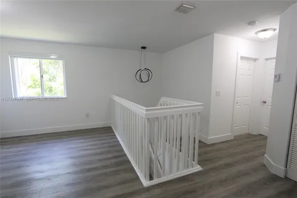 a view of a room with wooden floor and windows