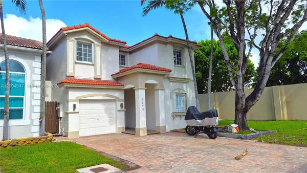 a view of a house with a patio and a yard