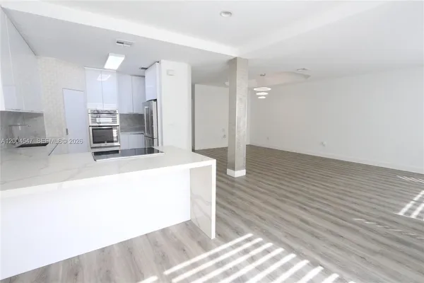 a kitchen with stainless steel appliances kitchen island granite countertop a refrigerator a stove and a sink