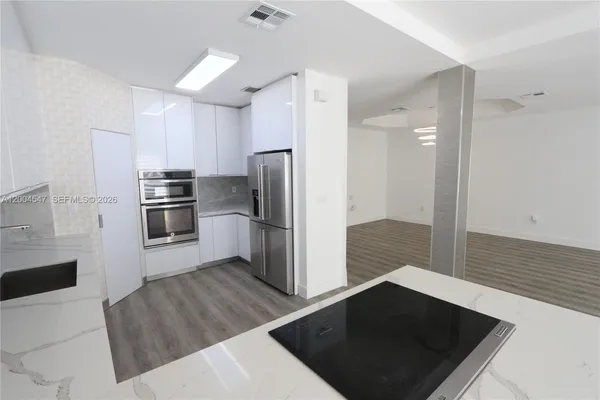 a kitchen with wooden floors and stainless steel appliances