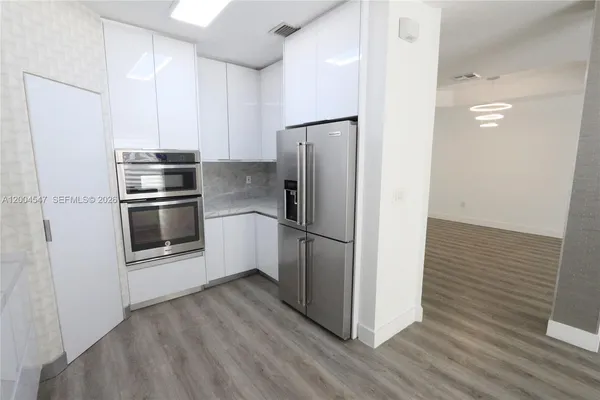 a kitchen with a refrigerator and a sink