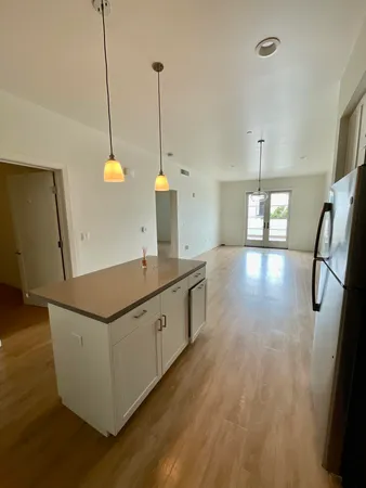 a kitchen with stainless steel appliances granite countertop a sink a refrigerator a counter space and cabinets