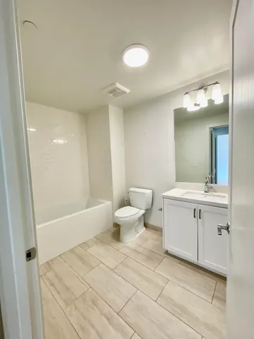 a bathroom with a sink a toilet and a large mirror