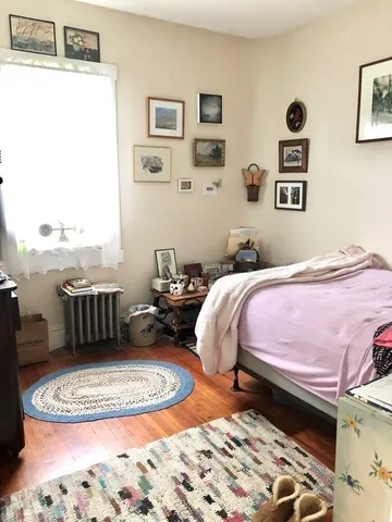 a bedroom with a bed dresser and a window