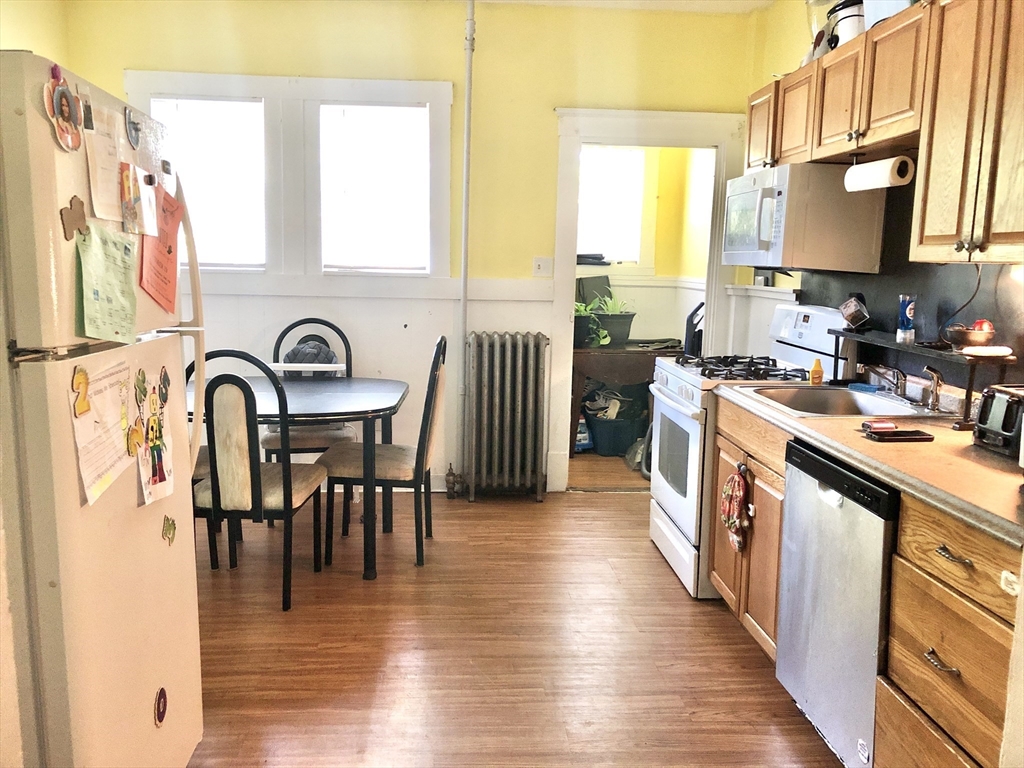 20-22 Hedge Road Plymouth, MA 02360 - Photo 3 of 29 a kitchen with stainless steel appliances granite countertop a stove top oven a sink a dining table and chairs with wooden floor