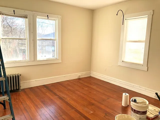 a view of a livingroom with wooden floor and a window