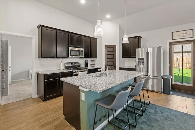 a kitchen with stainless steel appliances granite countertop a stove refrigerator and a microwave