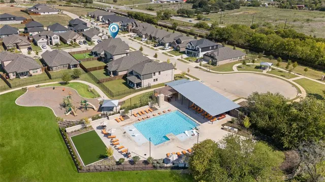 an aerial view of a house with a swimming pool and outdoor seating