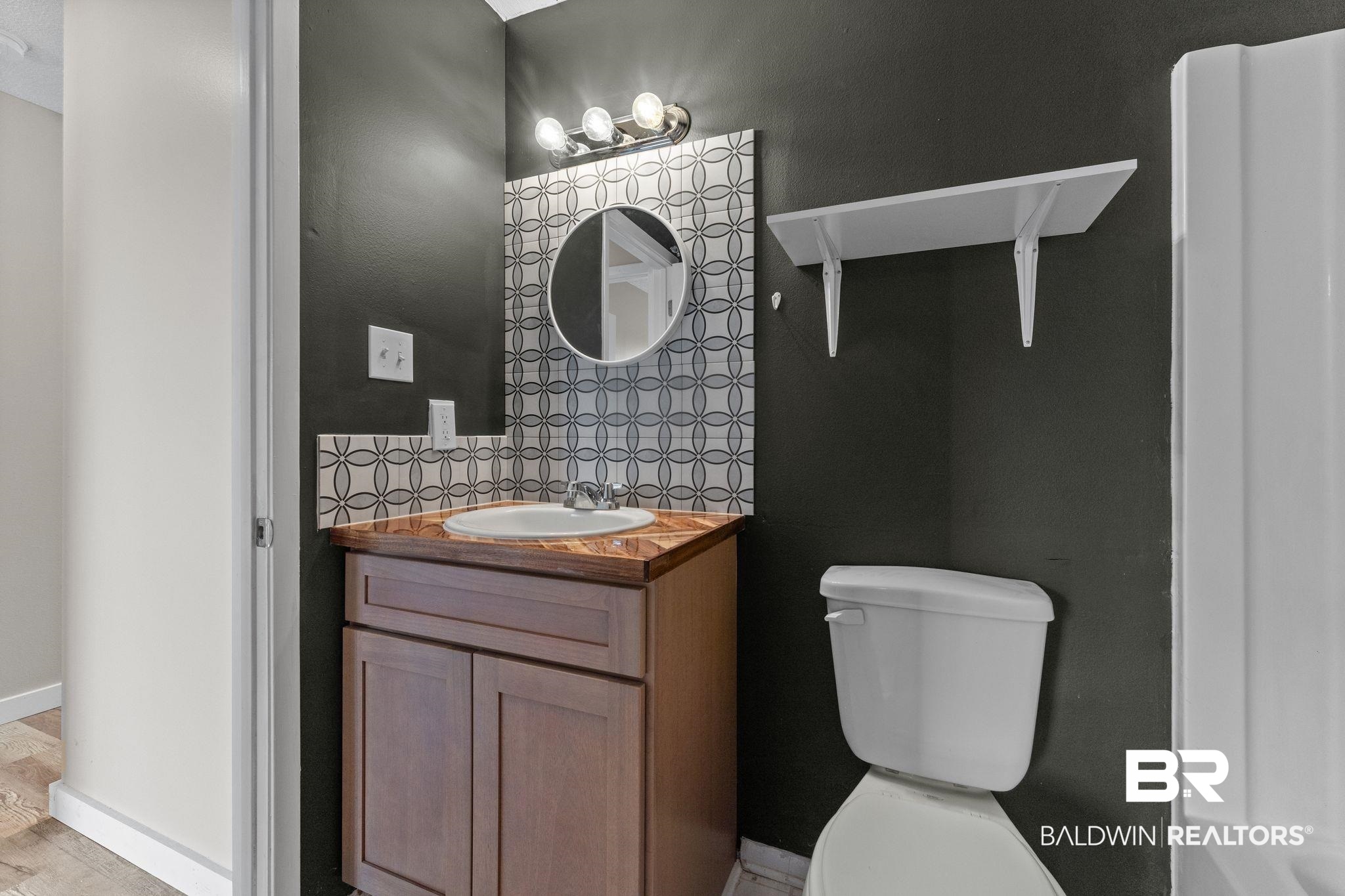 128 West Satsuma Avenue, Unit 128 Foley, AL 36535 - Photo 22 of 41 Bathroom featuring vanity and tasteful backsplash