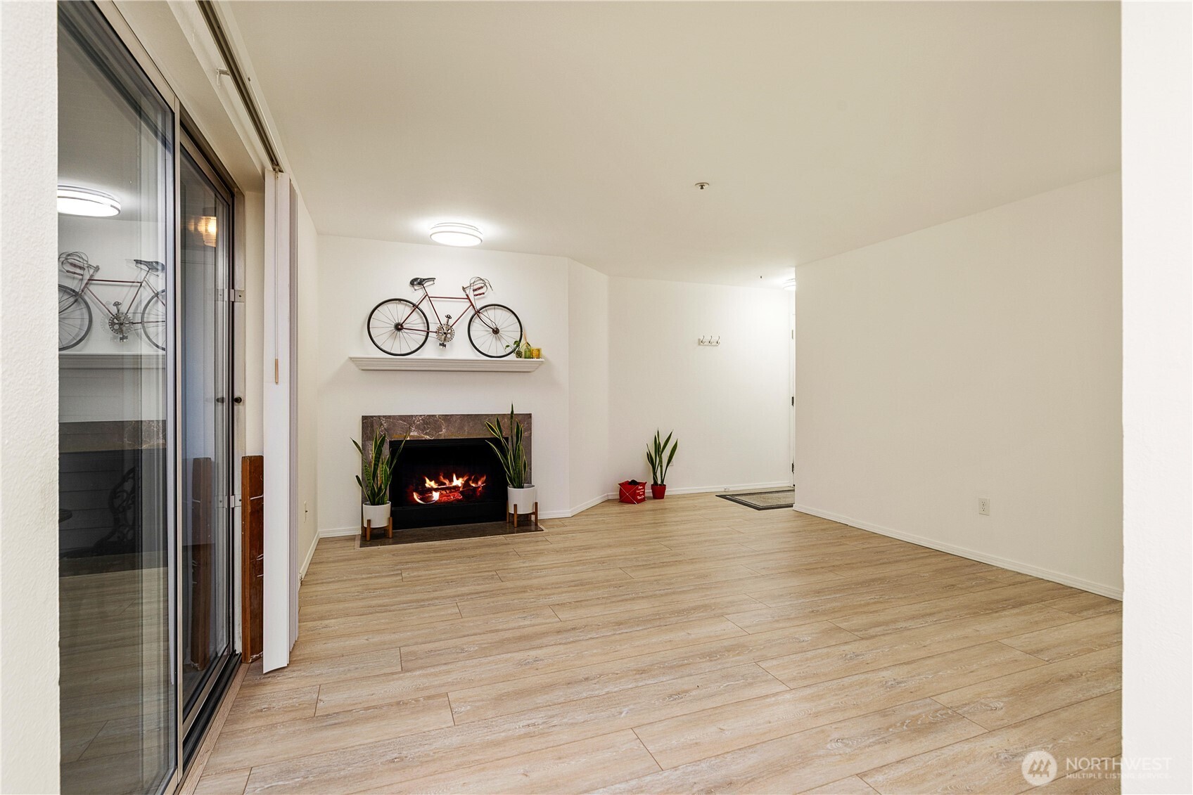 7453 Newcastle Golf Club Road, Unit G103 Newcastle, WA 98059 - Photo 6 of 37 a view of an empty room with wooden floor fireplace and a window