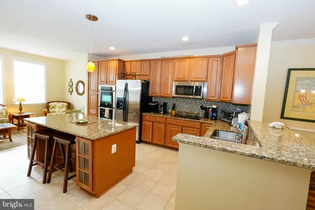a kitchen with granite countertop sink table and chairs