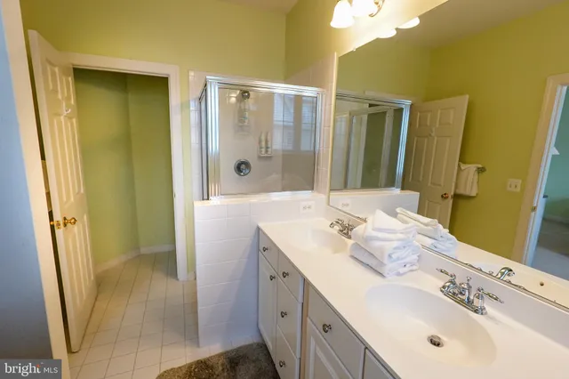 a spacious bathroom with a granite countertop sink mirror and shower