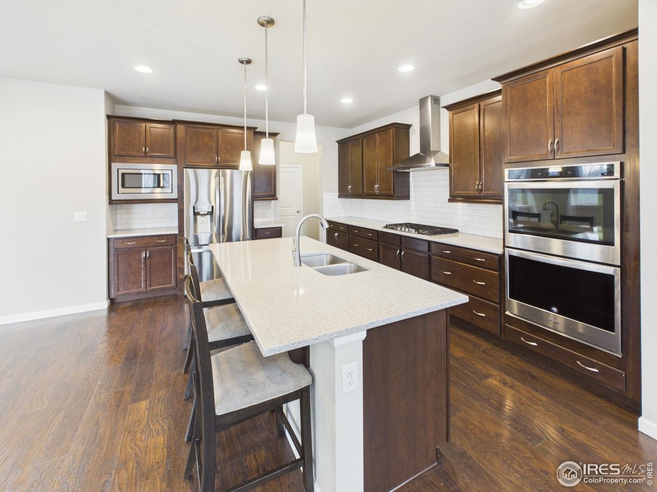 420 South 5th Street Berthoud, CO 80513 - Photo 12 of 47 a kitchen with a table chairs refrigerator and microwave