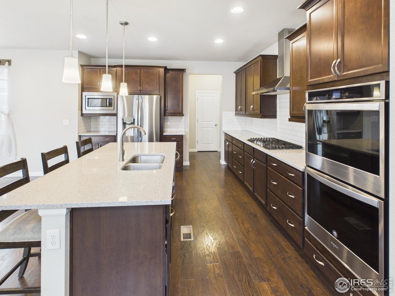 420 South 5th Street Berthoud, CO 80513 - Photo 4 of 47 a kitchen with stainless steel appliances kitchen island granite countertop a sink and cabinets