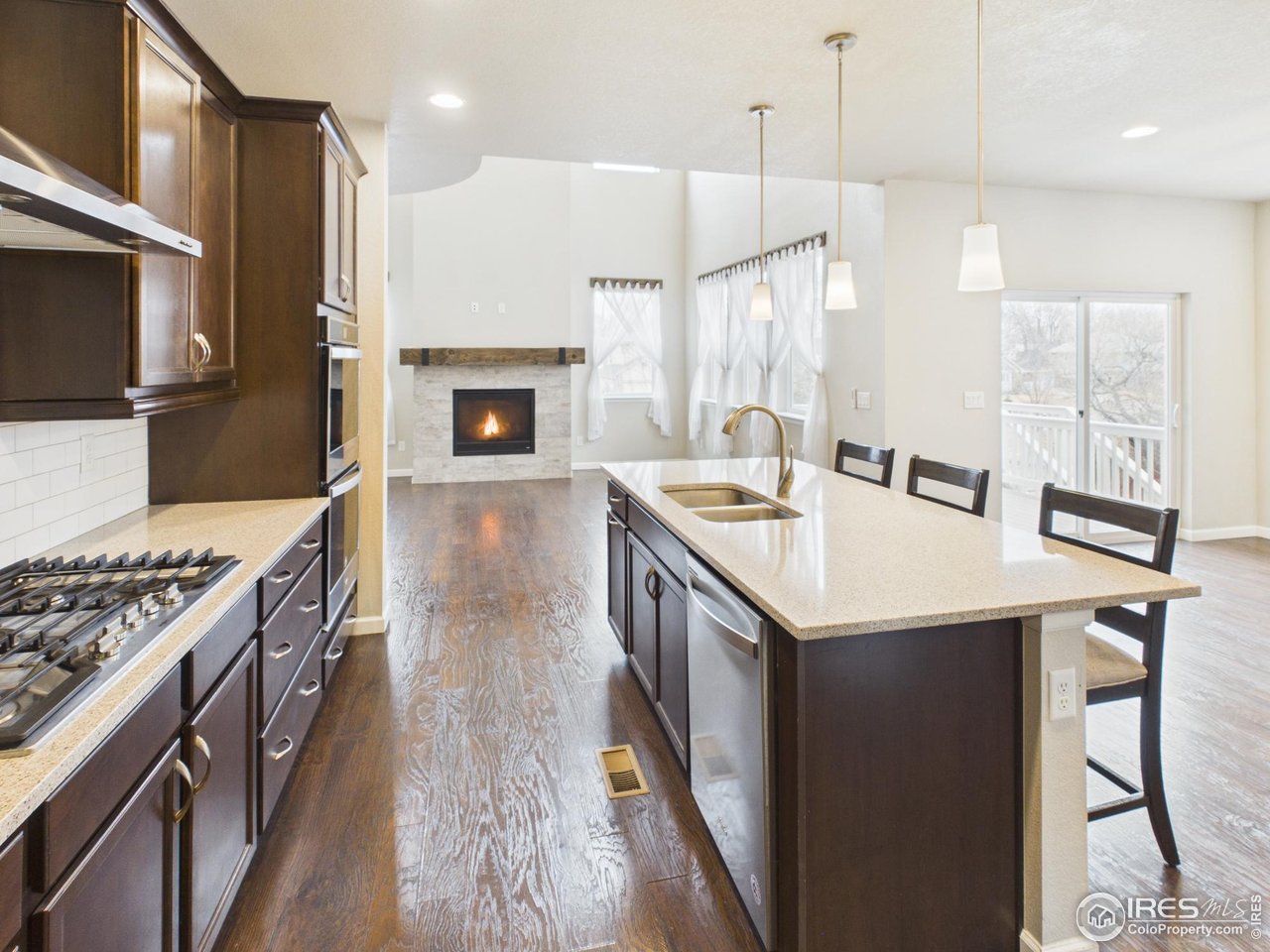 420 South 5th Street Berthoud, CO 80513 - Photo 7 of 47 a kitchen with granite countertop a sink a stove and a refrigerator