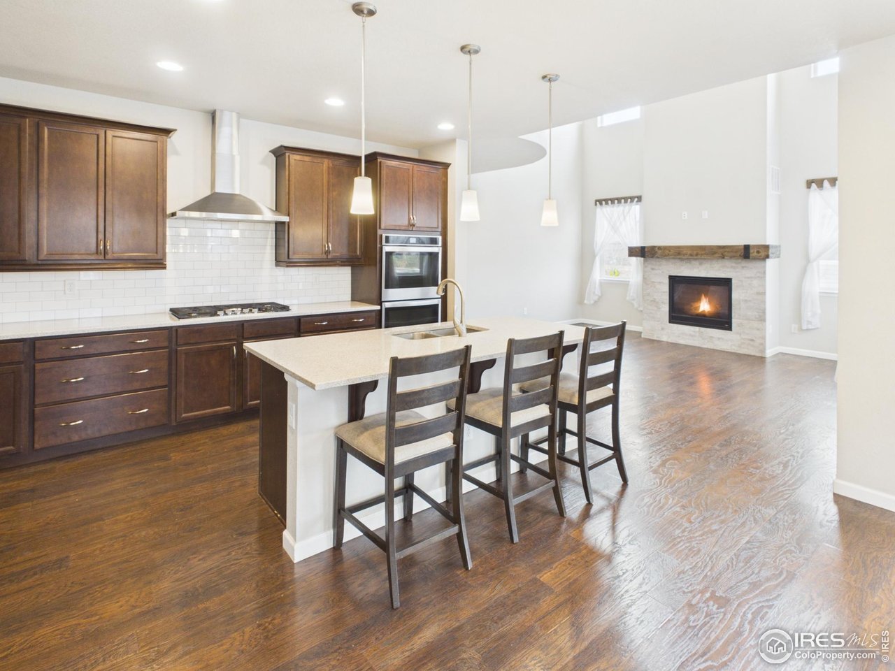 420 South 5th Street Berthoud, CO 80513 - Photo 9 of 47 a kitchen with stainless steel appliances granite countertop wooden floor and a refrigerator