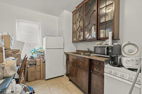 a kitchen with a refrigerator and a stove top oven