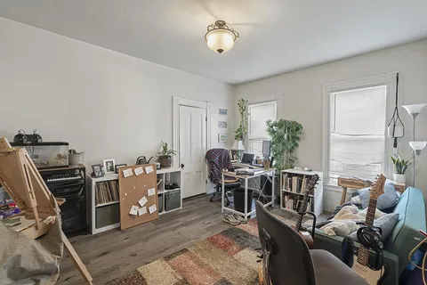 a living room with furniture a window and a flat screen tv