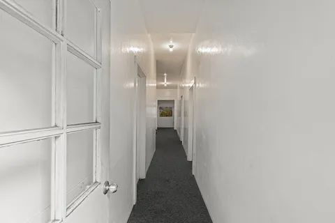 a view of a hallway with wooden shelves
