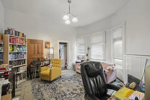 a living room with furniture a rug and a bookshelf