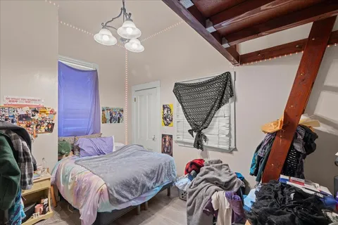 a bedroom with bed and a chandelier