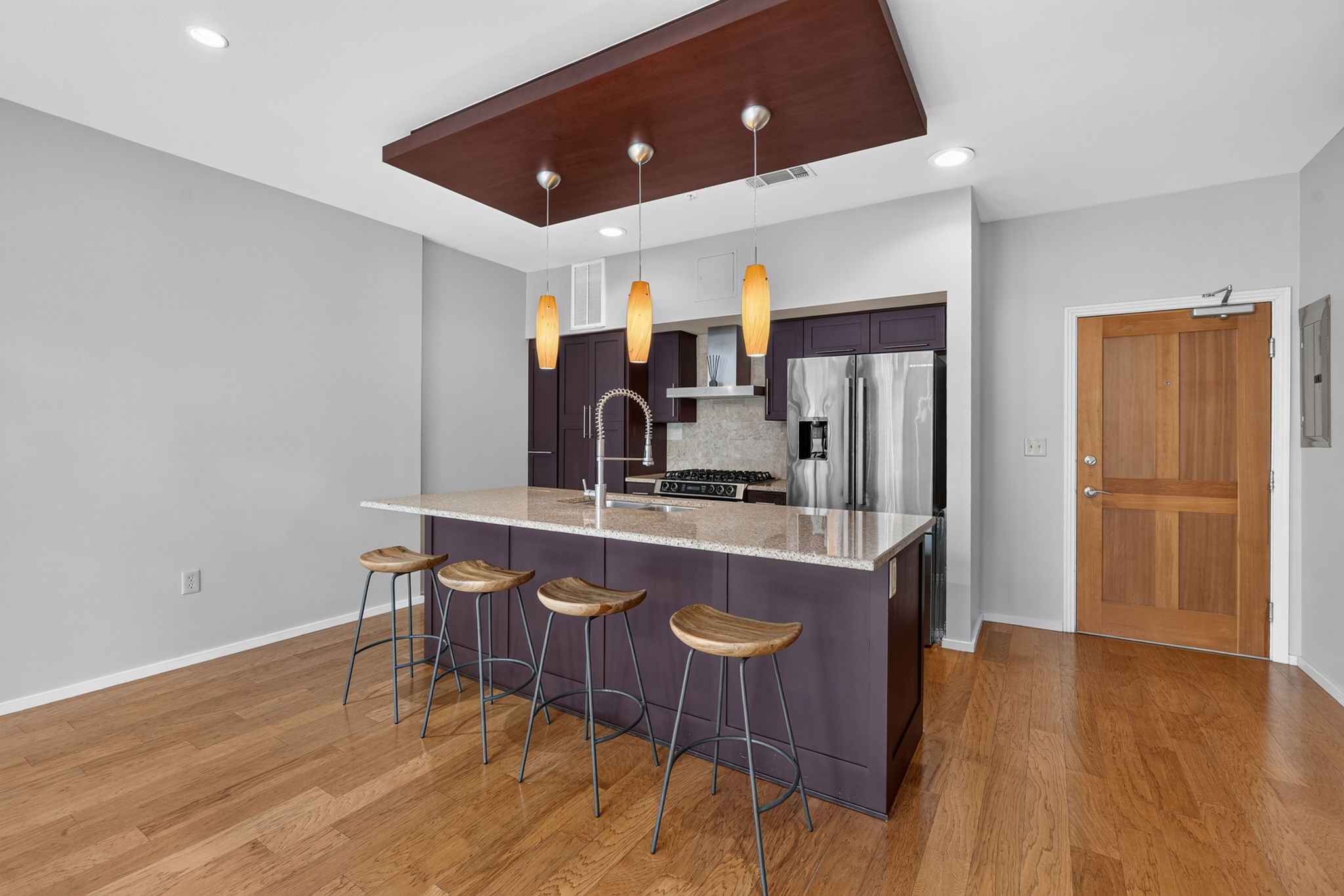 1600 Barton Springs Road, Unit 1302 Austin, TX 78704 - Photo 4 of 15 Warm hardwood flooring complements the modern kitchen island and sleek cabinetry in this open space.