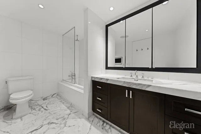 a bathroom with a toilet sink and mirror