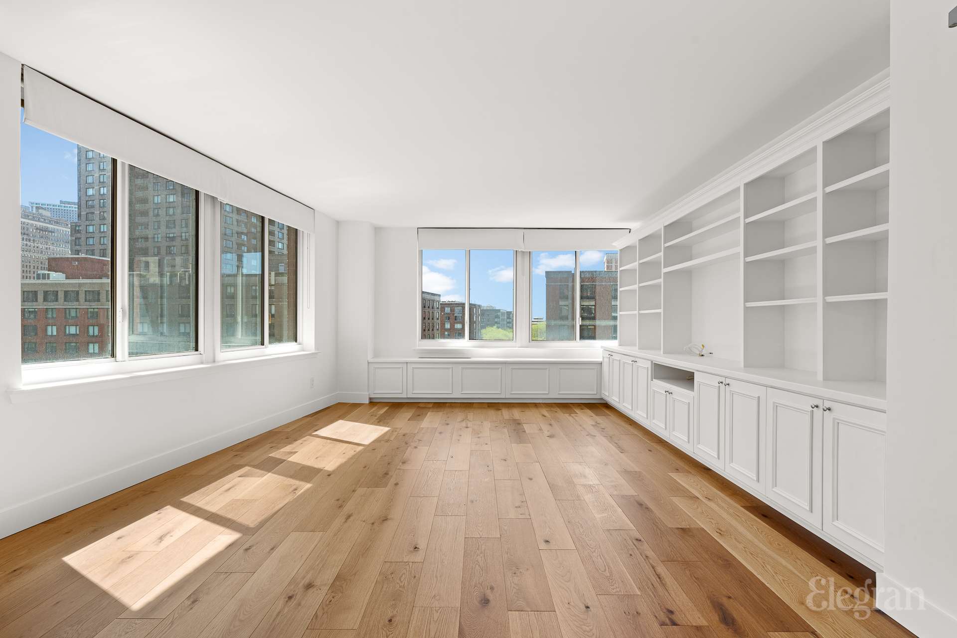 333 Rector Place, Unit 805 Manhattan, NY 10280 - Photo 2 of 28 a view of an empty room with wooden floor and windows