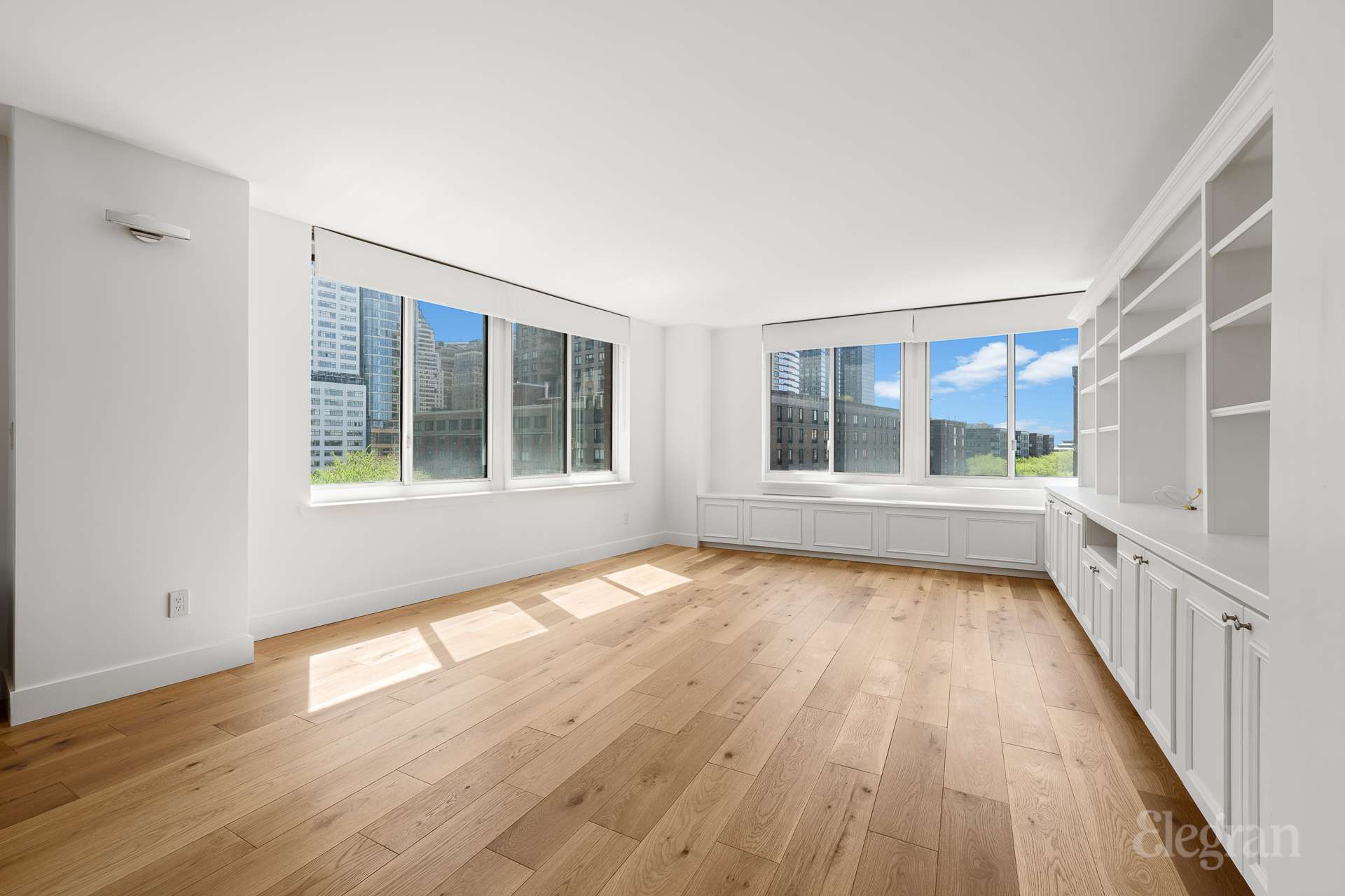 333 Rector Place, Unit 805 Manhattan, NY 10280 - Photo 4 of 28 a view of an empty room with wooden floor and a window