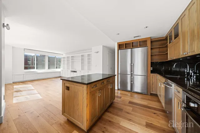 a kitchen with granite countertop a refrigerator a stove and wooden floors