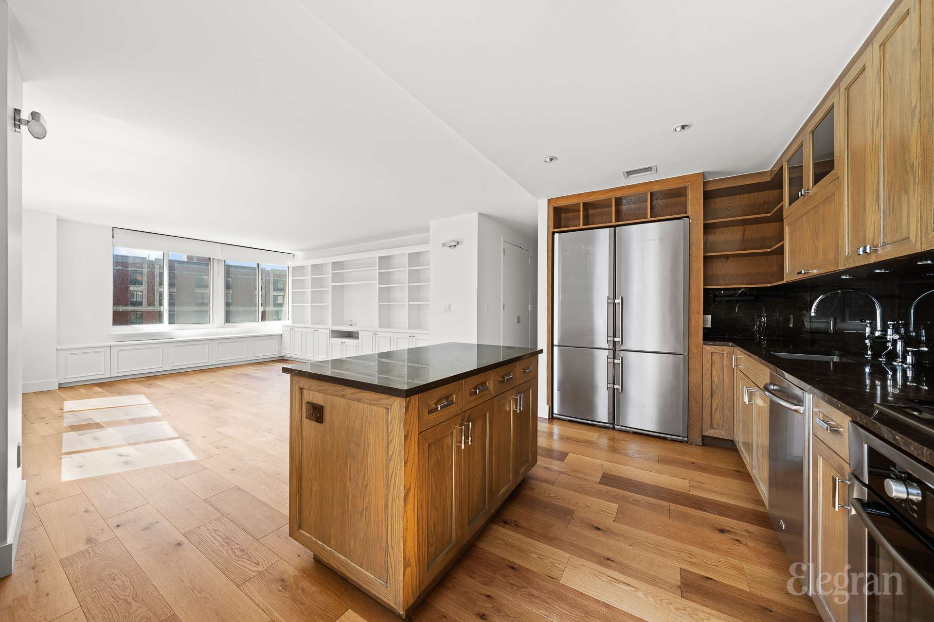 333 Rector Place, Unit 805 Manhattan, NY 10280 - Photo 6 of 28 a kitchen with granite countertop a refrigerator a stove and wooden floors