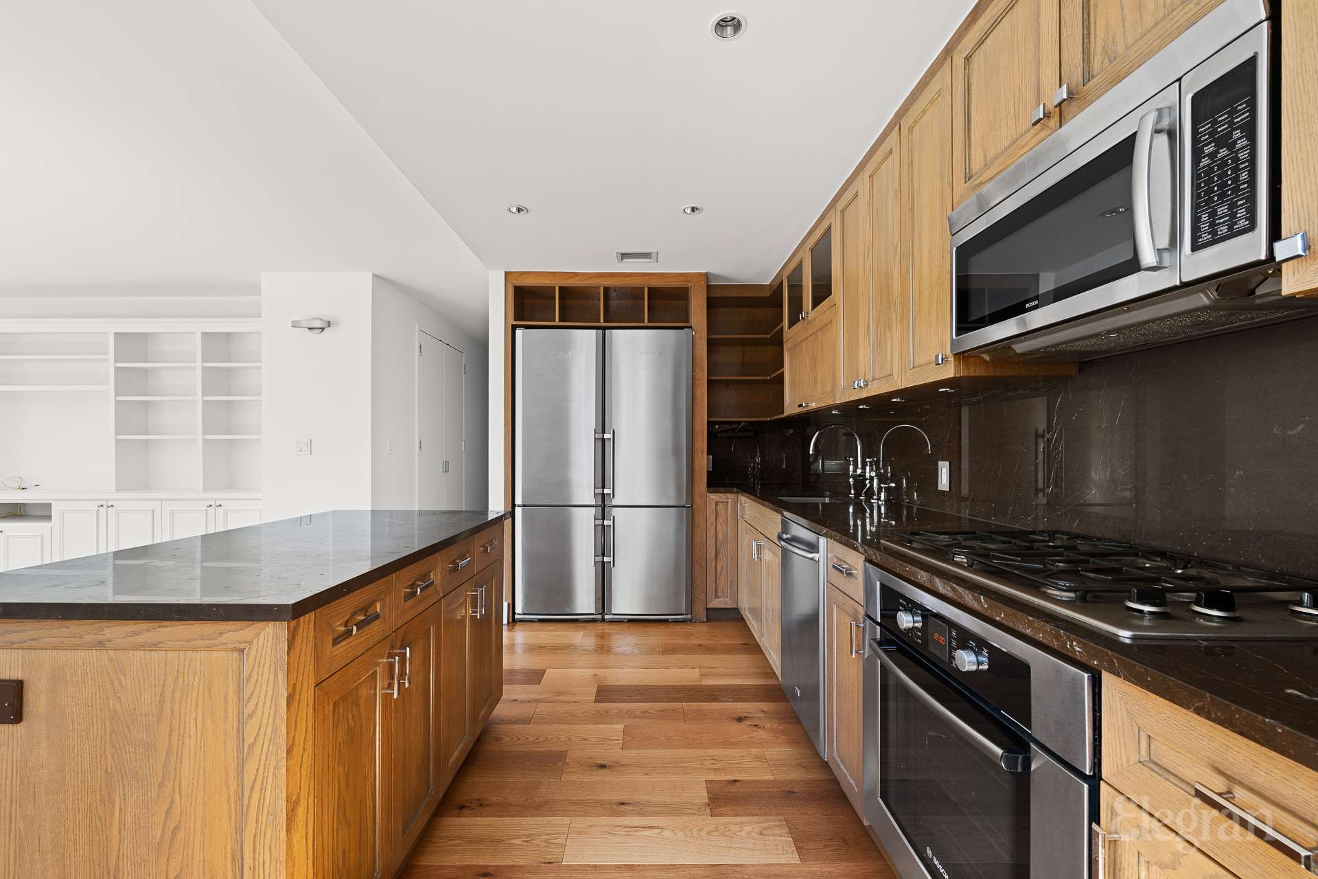 333 Rector Place, Unit 805 Manhattan, NY 10280 - Photo 7 of 28 a kitchen with stainless steel appliances a refrigerator a sink and wooden cabinets