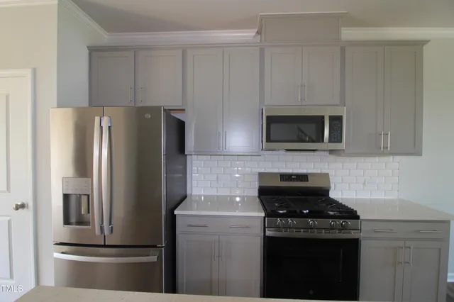 a kitchen with a refrigerator stove and microwave