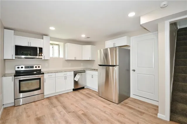 a kitchen with stainless steel appliances a refrigerator sink and microwave