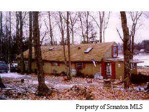 a view of a house with a yard covered with snow in front of it