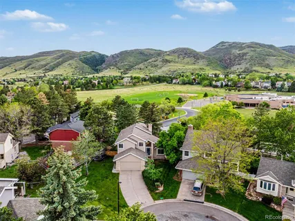 an aerial view of residential houses with outdoor space and trees