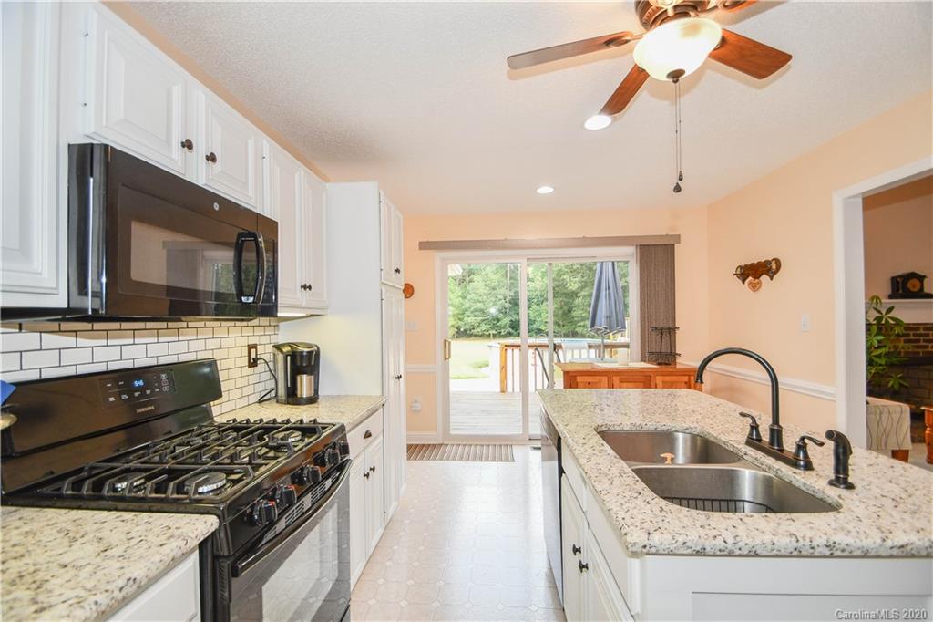 3400 Helms Pond Road Monroe, NC 28110 - Photo 18 of 24 a kitchen with stainless steel appliances granite countertop a stove a sink and a microwave