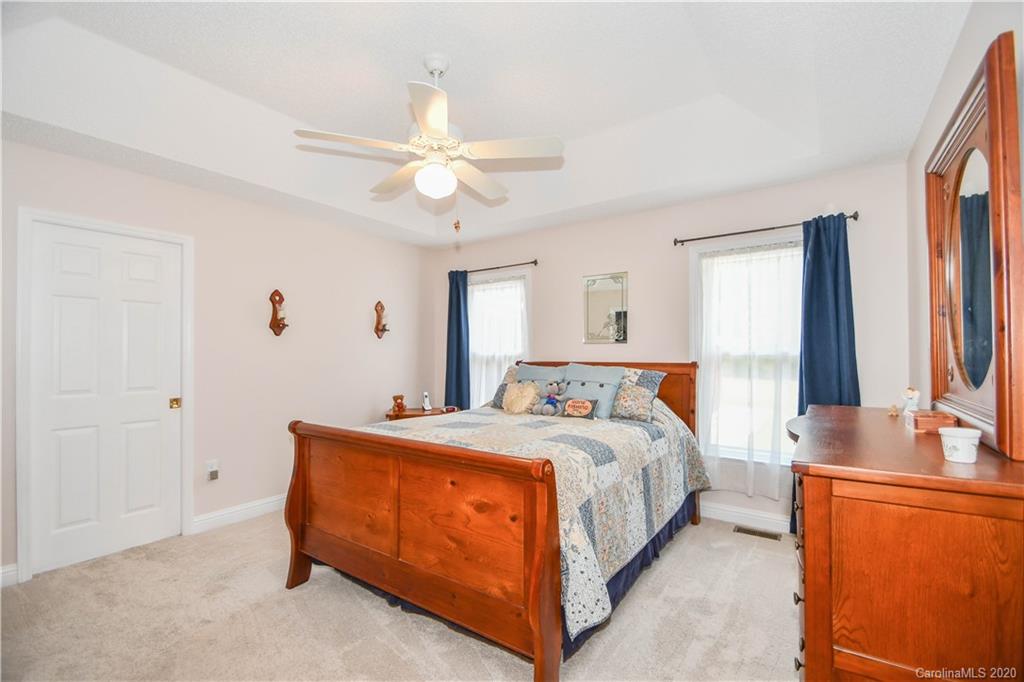 3400 Helms Pond Road Monroe, NC 28110 - Photo 21 of 24 a bedroom with a bed and a chandelier