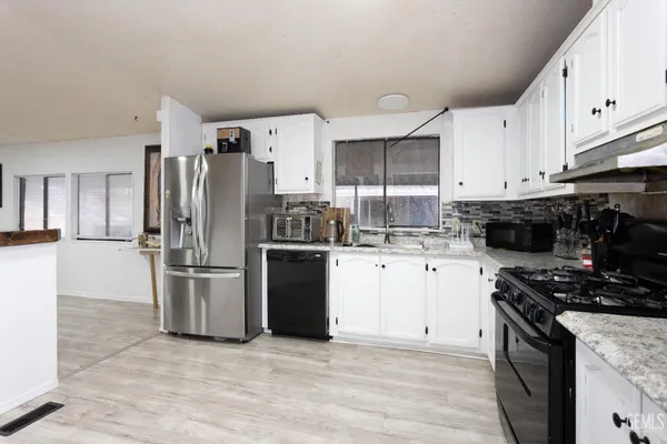 a kitchen with stainless steel appliances a refrigerator stove microwave and sink