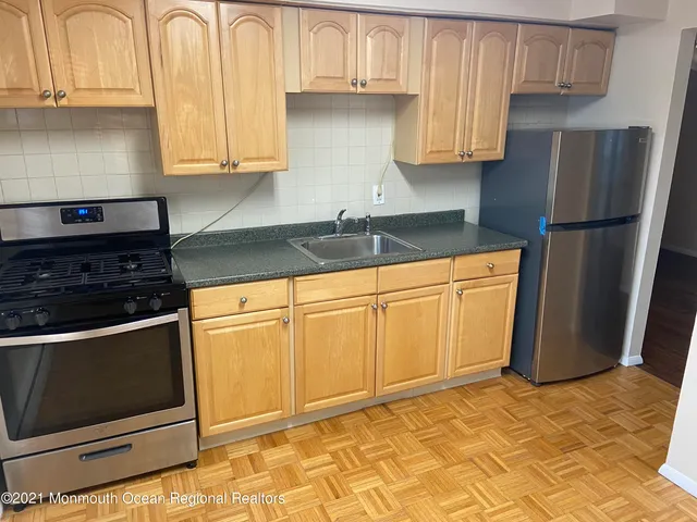 a kitchen with stainless steel appliances granite countertop a stove a refrigerator and a sink