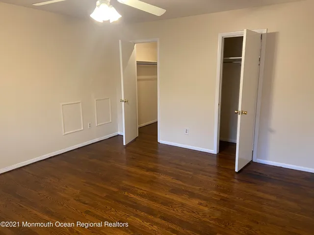 an empty room with wooden floor and closet