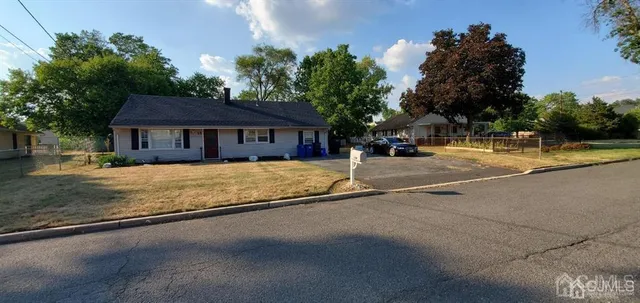 a view of a house with a yard and a large tree