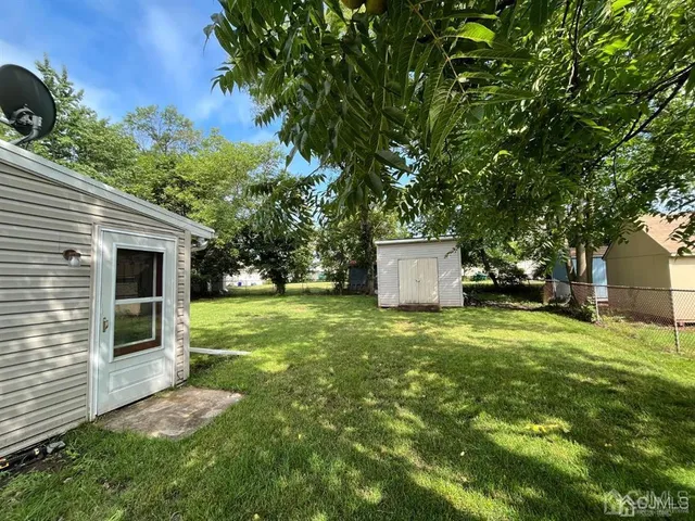 a backyard of a house with plants and tree