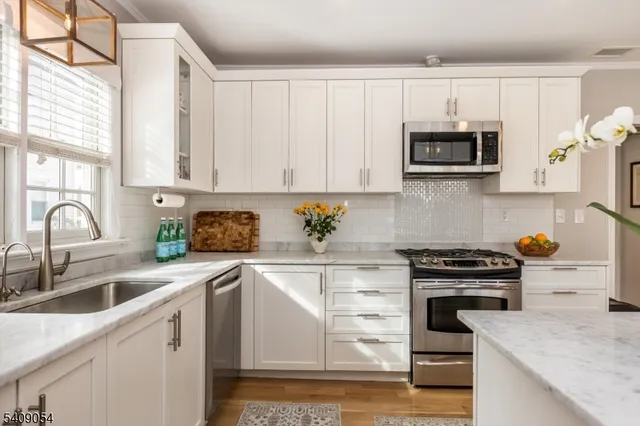 a kitchen with stainless steel appliances granite countertop a sink and cabinets