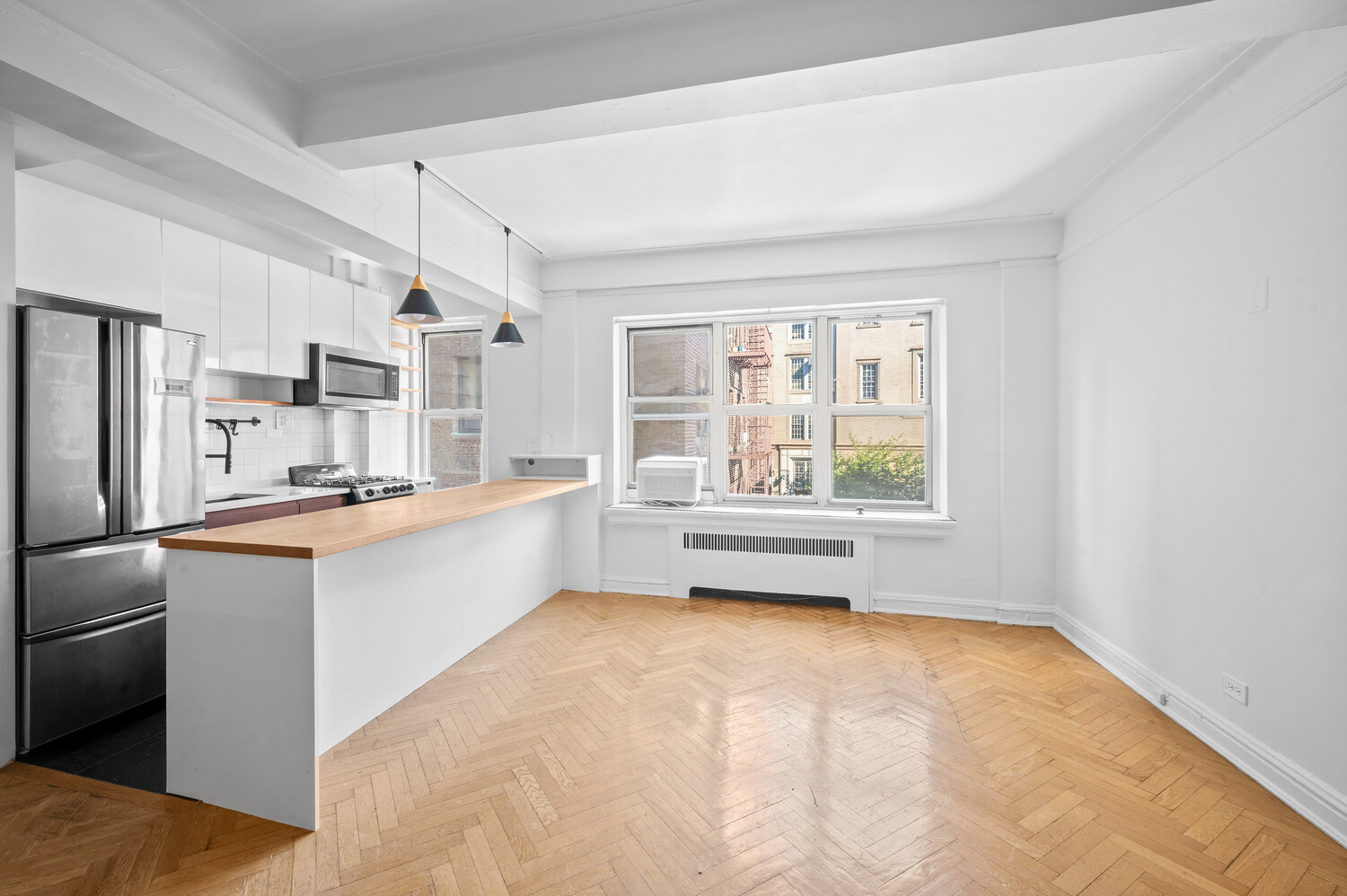 255 Cabrini Boulevard, Unit 3F Manhattan, NY 10040 - Photo 2 of 7 a kitchen with stainless steel appliances a white cabinets and a window