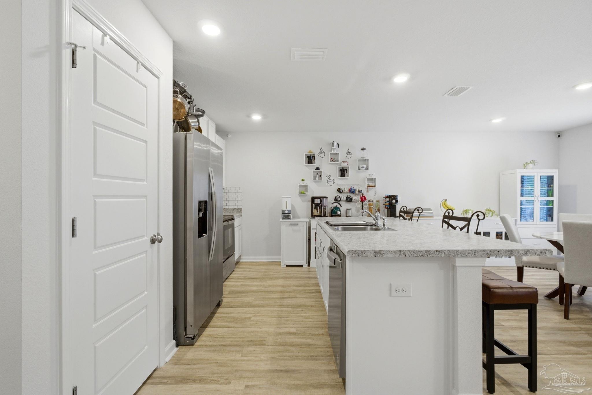 6126 Native Dancer Way Pensacola, FL 32526 - Photo 22 of 40 a kitchen with kitchen island a sink and refrigerator