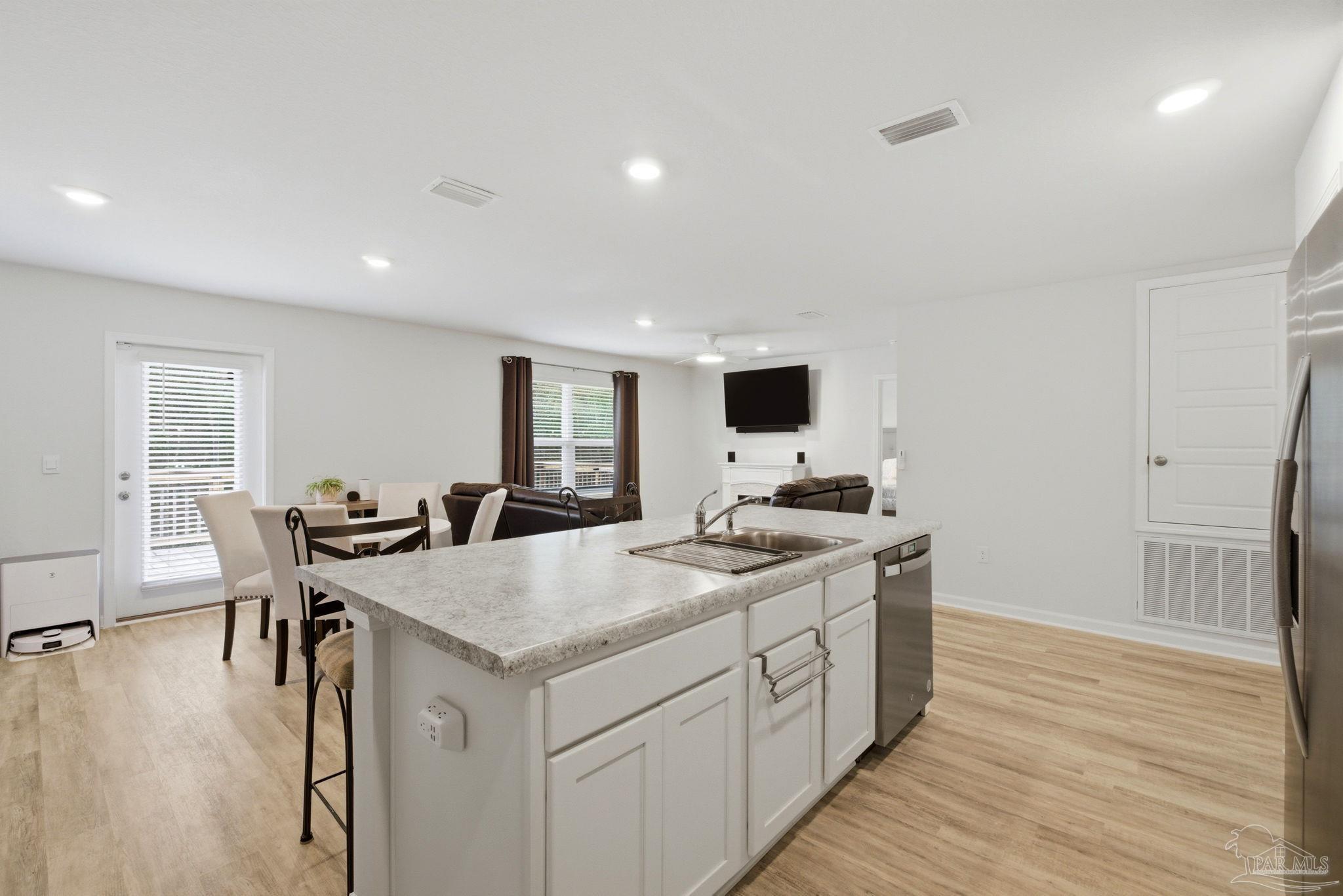 6126 Native Dancer Way Pensacola, FL 32526 - Photo 23 of 40 a kitchen with a stove a refrigerator and wooden floor