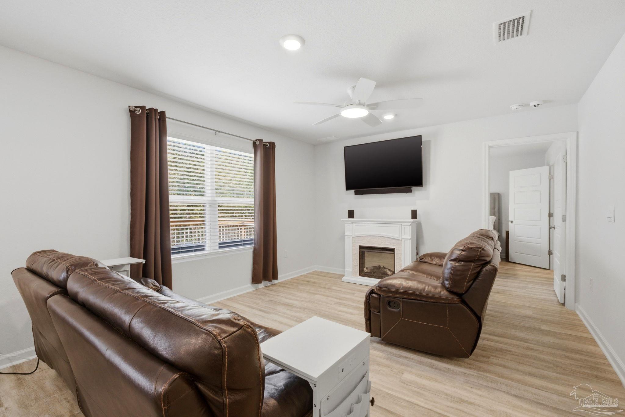 6126 Native Dancer Way Pensacola, FL 32526 - Photo 29 of 40 a living room with furniture a fireplace and a flat screen tv